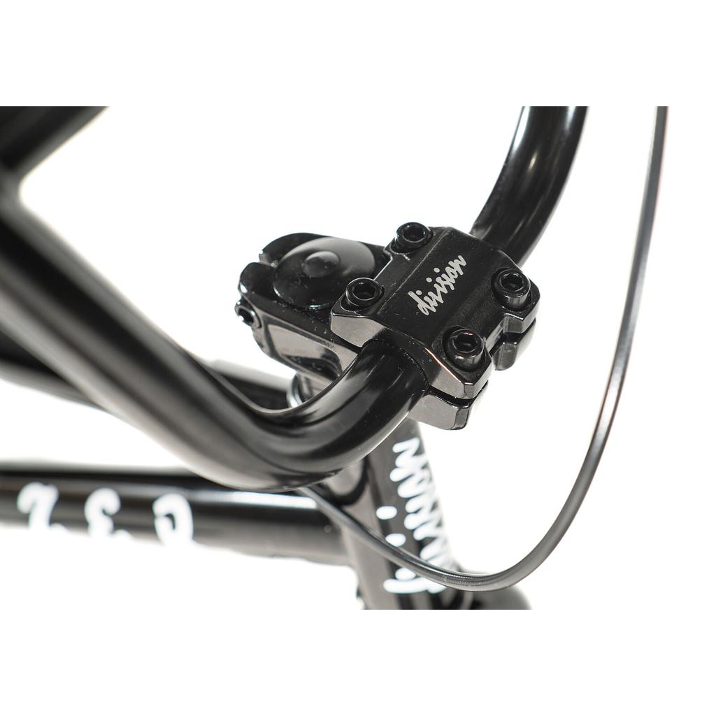 Close-up of a black handlebar stem with visible bolts and cable, featuring "division" branding—ideal for beginner riders or as the handlebar stem on the Division Blitzer 18 Inch Bike for kids.