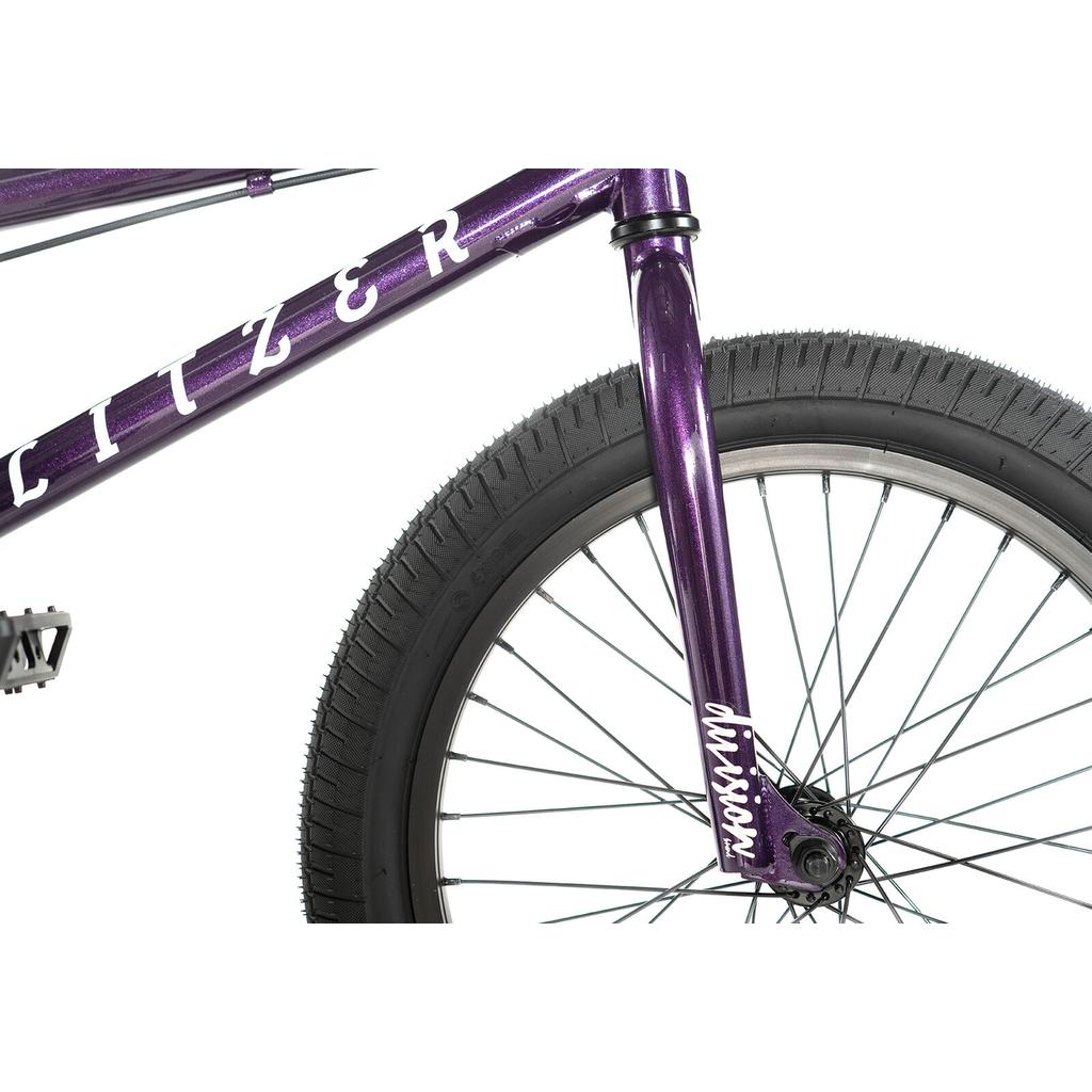 Close-up of the front section of the Division Blitzer 18 Inch Bike with a purple Hi-Ten frame, highlighting the front tire, fork, spokes, and visible branding.