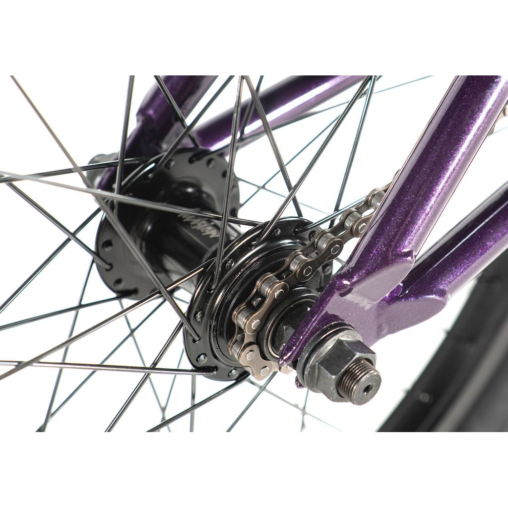 Close-up of the Division Blitzer 20 Inch Bike’s rear wheel hub, chain, and purple frame with 20” wheels, highlighting the spokes, axle nut, and detailed bike components.