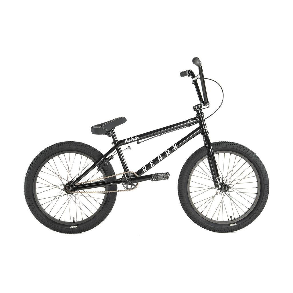 The Division Reark 20 Inch Bike is a black BMX with thick tires, lightweight Hi-Tensile steel frame, padded seat, straight handlebars, rear pegs, and sealed bottom bracket—shown in profile against a white background.