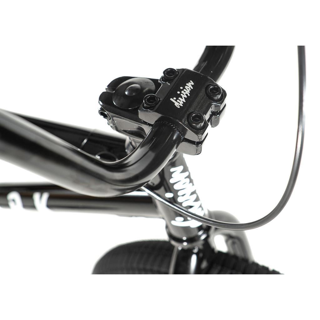 Close-up of the Division Reark 20 Inch Bike’s black handlebars, stem with "Division" branding, and front brake cable, featuring sturdy Hi-Tensile steel construction for lasting durability.