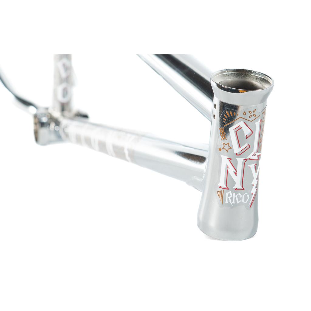 Close-up of the Colony Rico 'Lite' Frame, a silver BMX frame with full CrMo construction and vibrant graphic designs on the head tube and downtube. Ideal for tech park ramp riders, shown against a white background.