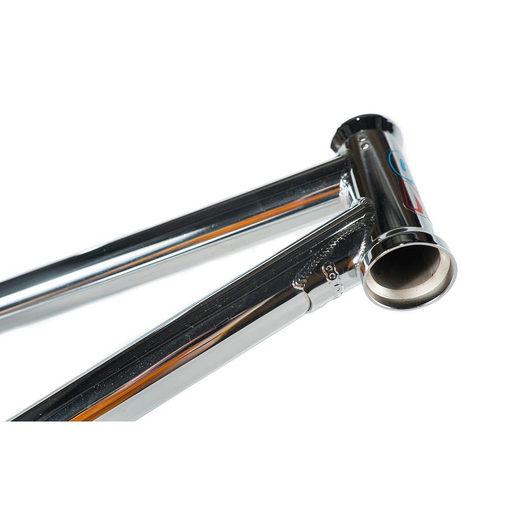 Close-up of a shiny chrome Colony Enishi Flatland Frame (Kio Hayakawa Signature), focusing on the head tube and top tube joints against a white background.