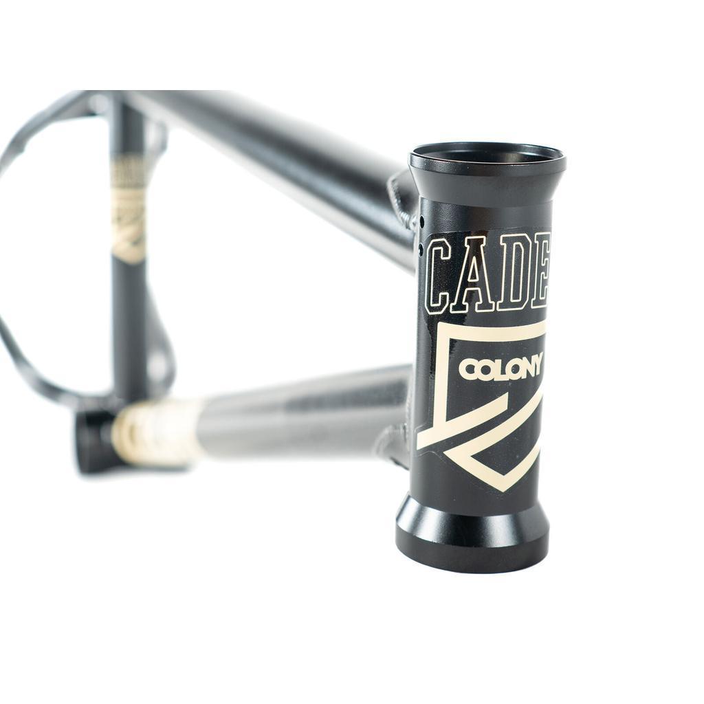 Close-up of a black Colony Cadet 20 inch BMX frame featuring "CADET" and "COLONY" logos in white on the head tube and down tube, designed with park and street geometry.