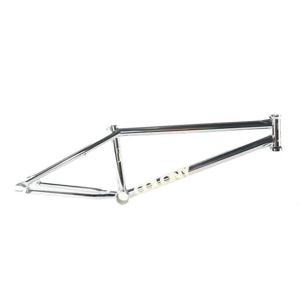 The Colony Cadet 20 inch Frame is a silver chromoly BMX frame featuring a simple geometric design, ideal for park and street riders, with "COLONY" printed on the side.