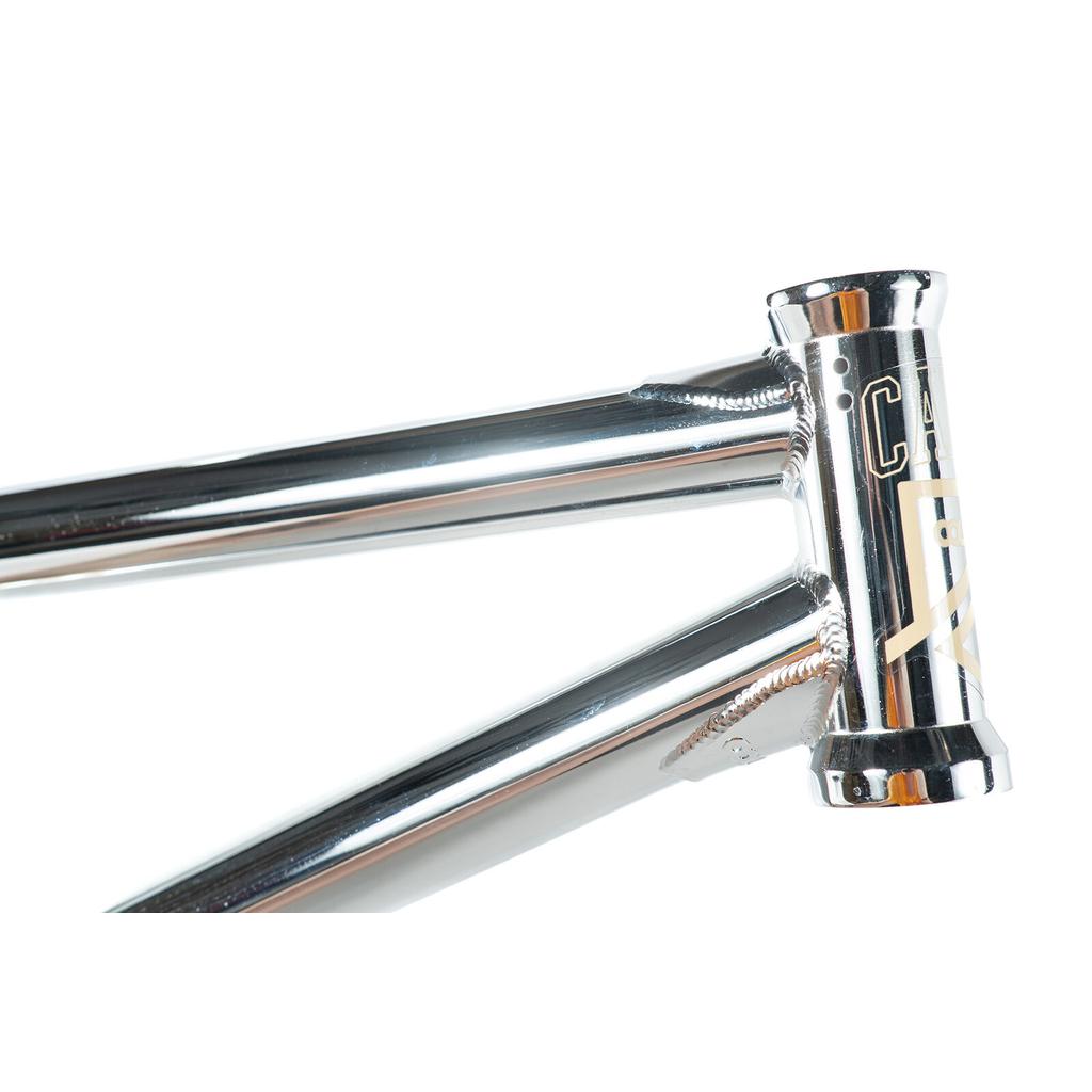 A close-up of the Colony Cadet 20 inch Frame shows its polished chromoly head tube, top tube, and down tube with visible welds and part of the Colony Cadet logo.