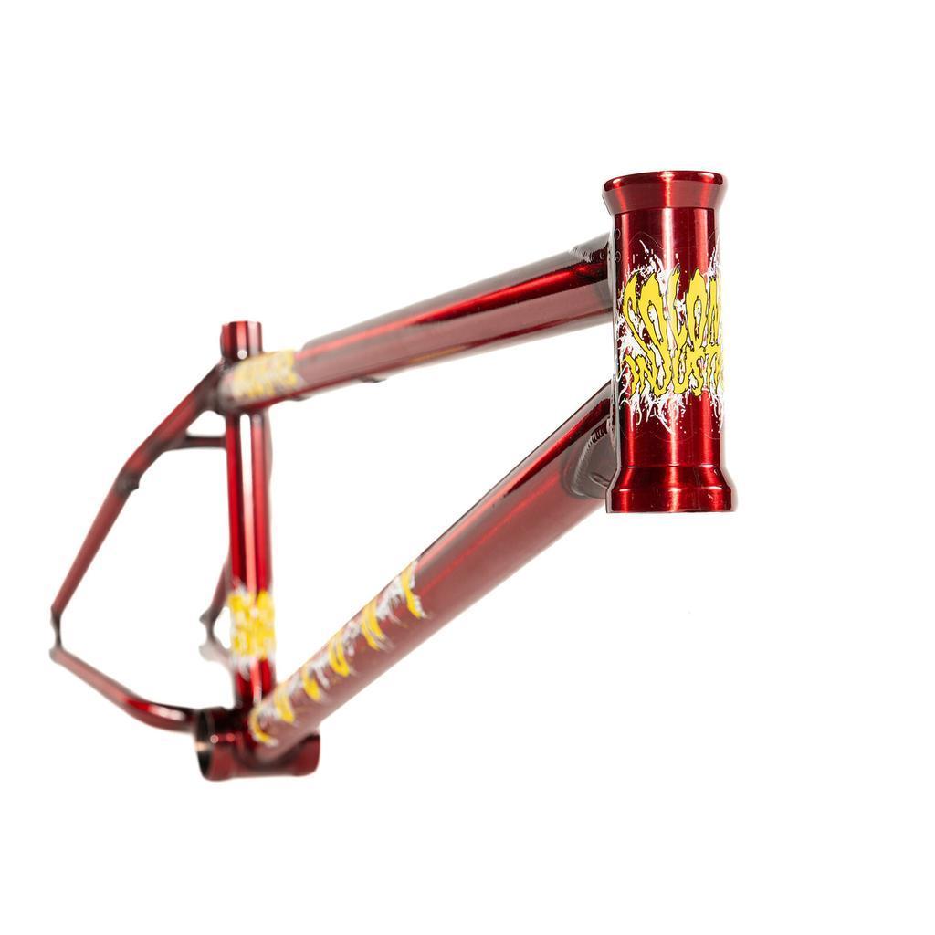 Shiny red Colony Injustice Frame (Tom Justice Signature) featuring yellow and white graphic decals, displayed from a front angle on a white background. Inspired by Tom Justice’s iconic style.