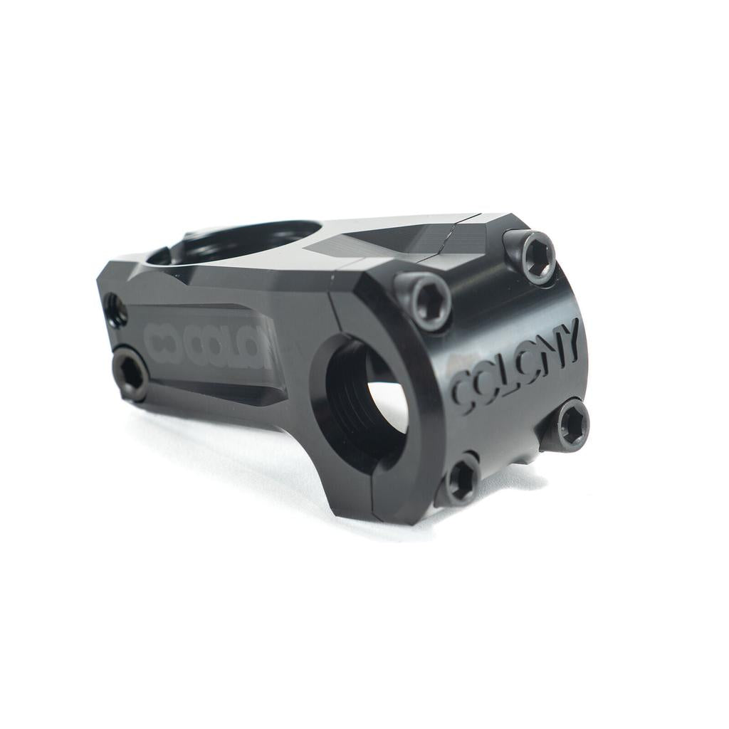The Colony Official Front Load Stem is a black BMX stem made from durable 7075T6 alloy, featuring "Colony" engraved on the front and four bolt holes for secure handlebar attachment in a classic front load design.