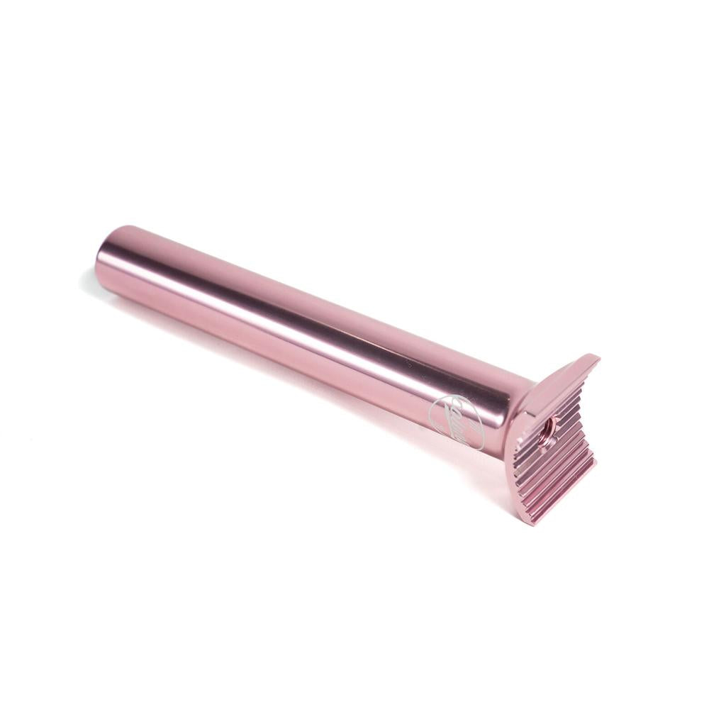 The Colony Pivotal Seat Post 185mm is a pink metal seat post with a straight design and flat, ridged head—crafted with precision like a lightweight razor—shown on a white background.