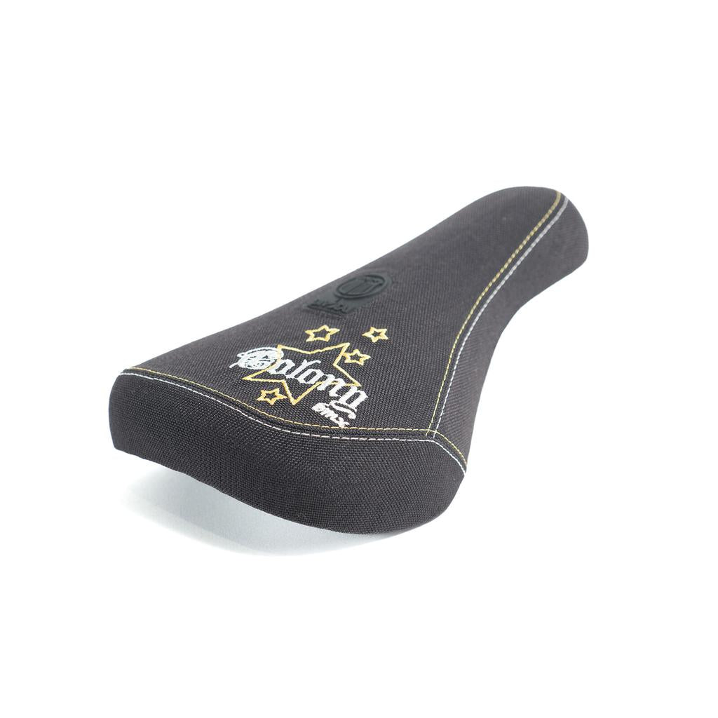 Colony Stars 2005 Mid Pivotal Seat: mid-sized BMX seat with reissue-inspired star designs, yellow stitching, and "Colony" embroidered in white on the rear, photographed on a white background.