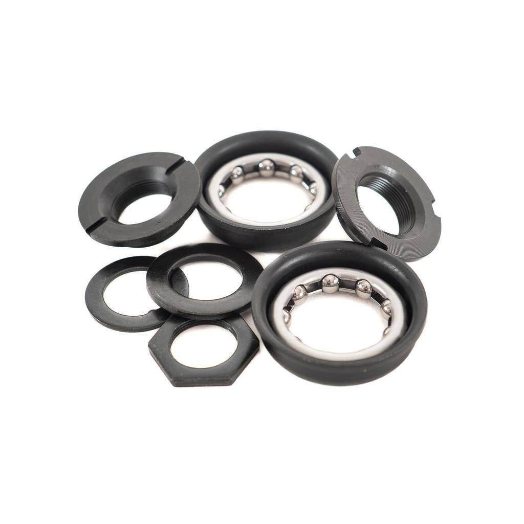 Family USA BB Bottom Bracket parts including two ball bearing retainers, two threaded lockrings, two washers, and a hexagonal nut.