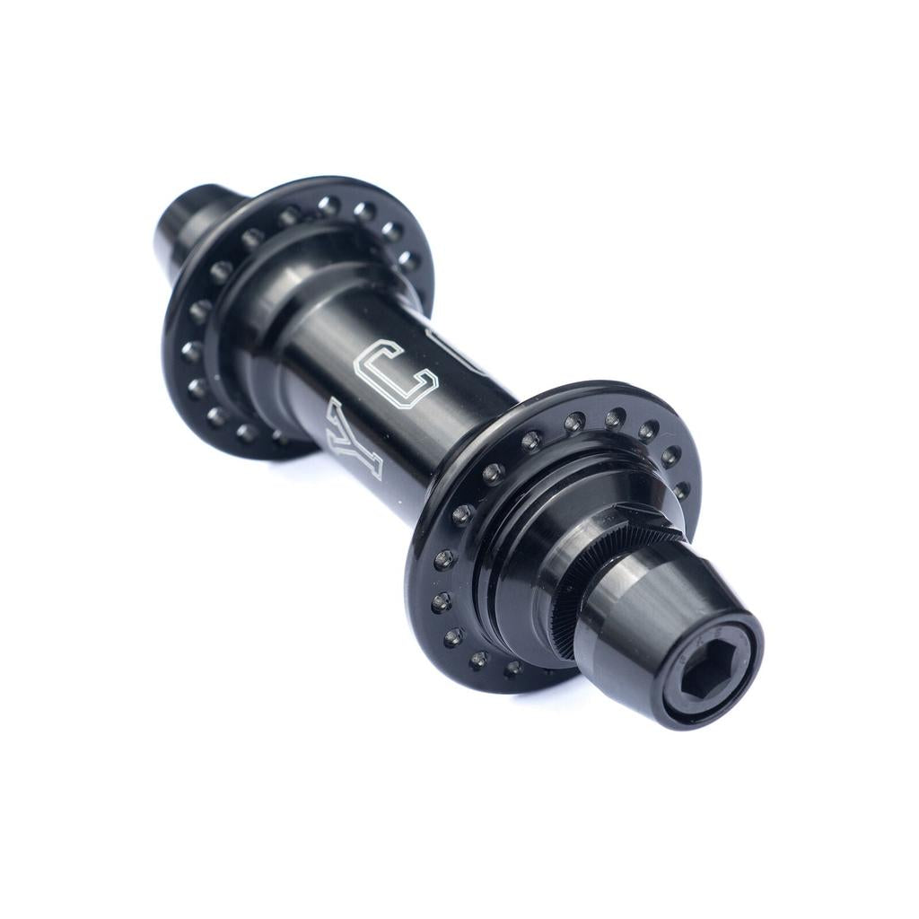 The Colony Wasp Supreme Hub Set in black metal features multiple spoke holes, dual flanges, a hexagonal axle fitting, and an alloy driver inspired by cassette hubs. Shown on a white background.