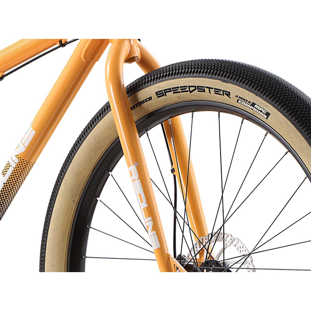 Close-up of the Redline RL 275 27.5 Inch Bike’s front wheel and fork, featuring a tan and black Speedster tire, black spokes, disc brake rotor, and an orange frame—perfect as a stylish BMX bike for adults.