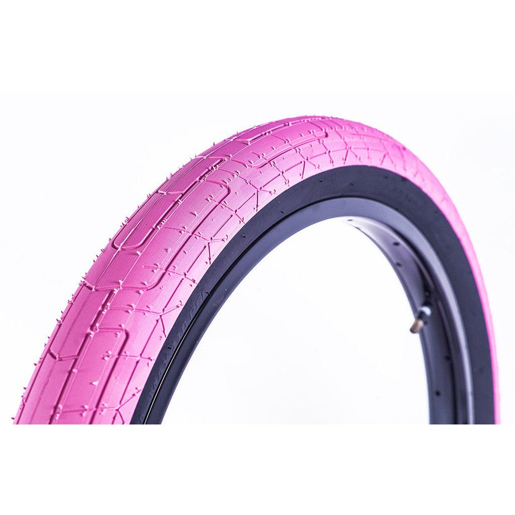 A pink Colony Griplock Tyre with a white tread design on a white background.
