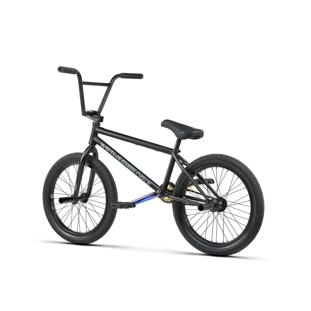 The Wethepeople Reason Shift 20 Inch Bike, featuring a black full chromoly frame, thick tires, upright handlebars, and rear pegs, is displayed against a white background.