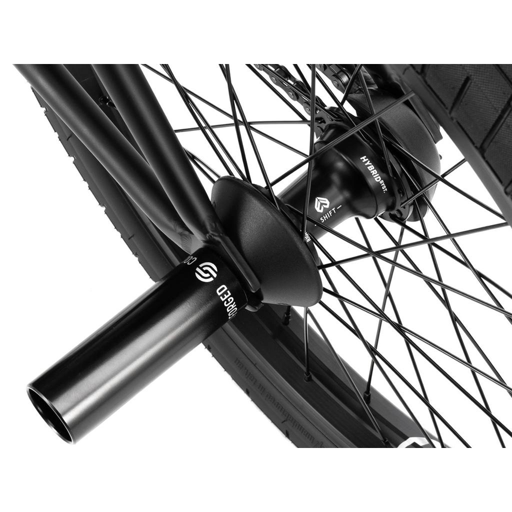 Close-up of the Wethepeople Reason Shift 20 Inch Bike’s premium BMX wheel featuring black spokes, a "HYBRANT SHIFT" hybrid freecoaster hub, and a "RAPID" metal axle peg on its durable full chromoly construction.