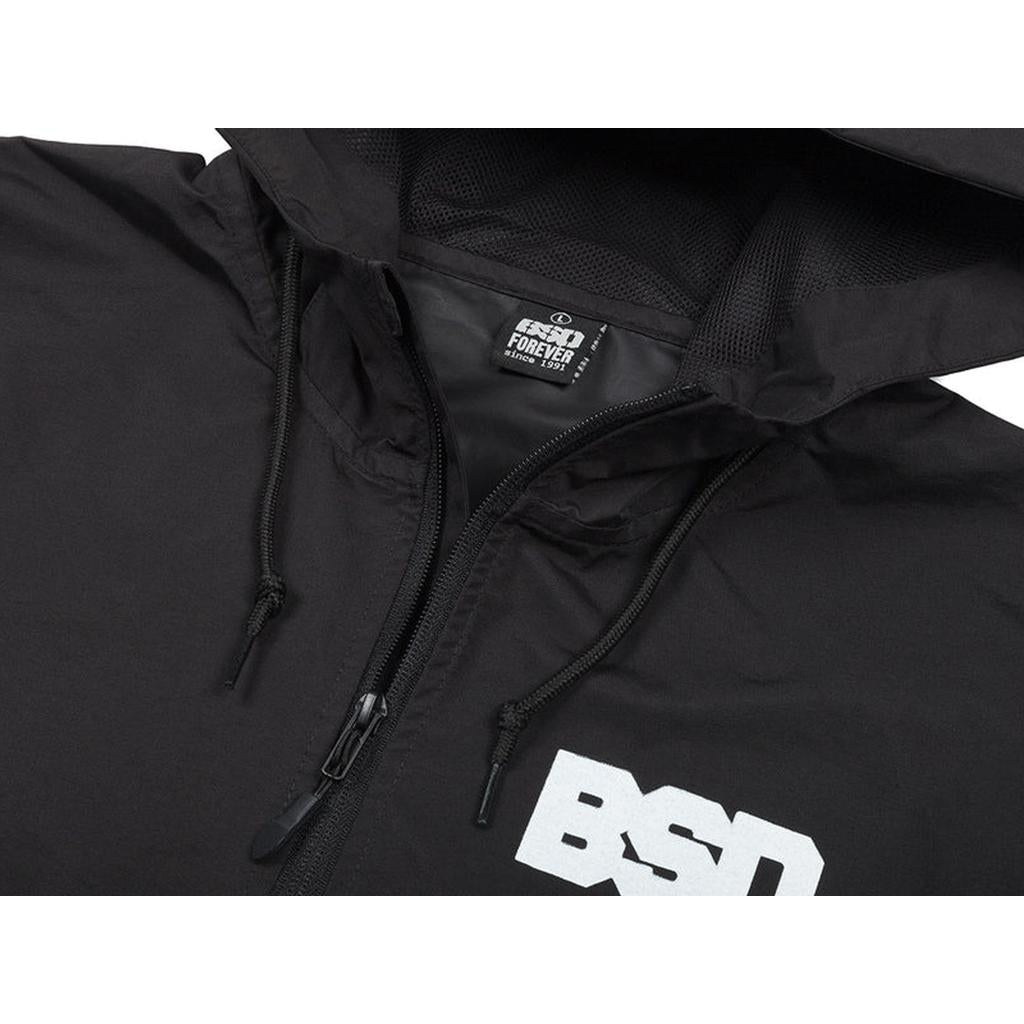 Close-up of a black BSD Athletic 91 Windbreaker Jacket with a zipper, "BSD" logo on the chest, and "BSD Forever" tag inside the collar, made from waterproof nylon.