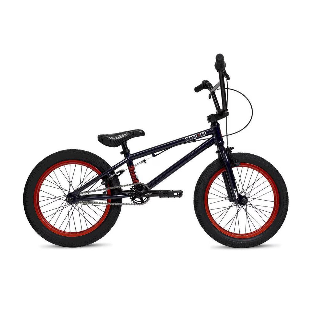 The DK Step Up 18 Inch Bike, shown from the side against a white background, features a black lightweight 6061 aluminum frame, red-rimmed wheels, padded seat, straight handlebars, and visible pedals.