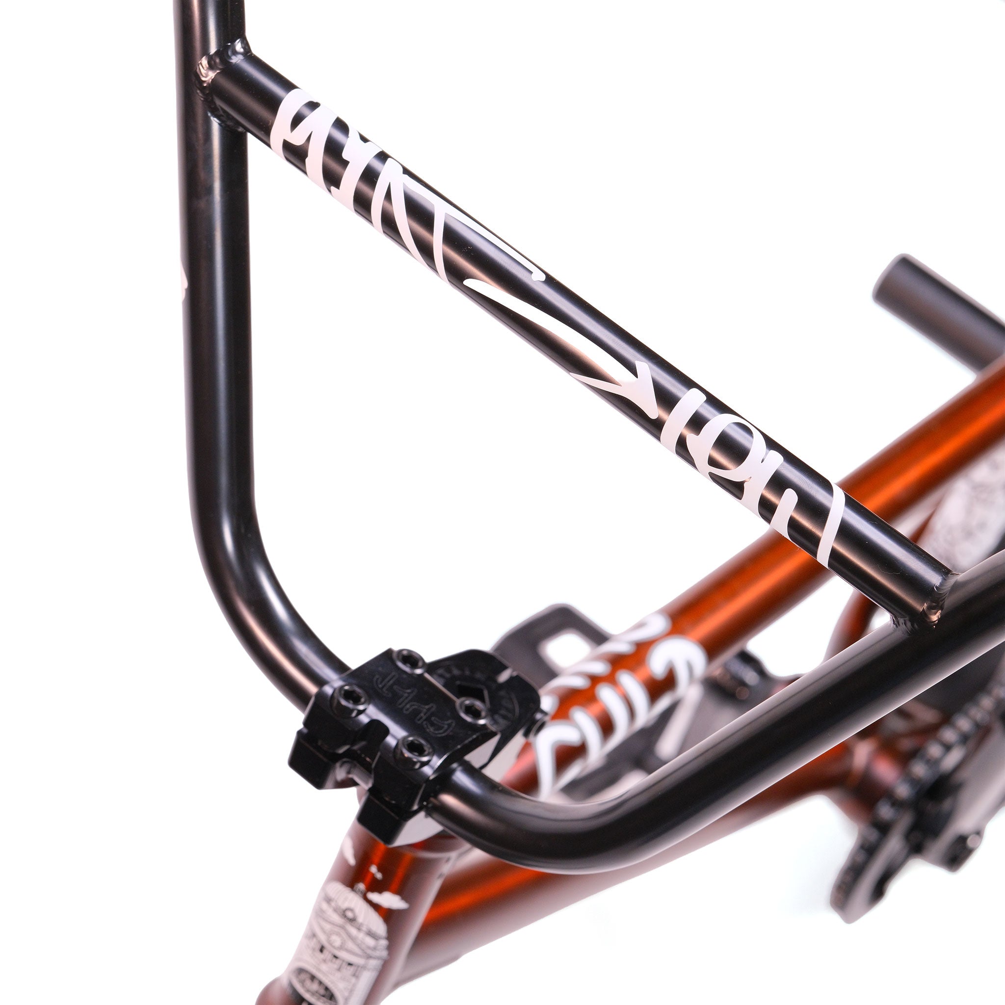 Close-up of a black BMX handlebar with white graphics on the Cult Dak X Eclat Custom 'Pat Freyne Signature' BMX bike, mounted on a red frame and shown from above against a white background.