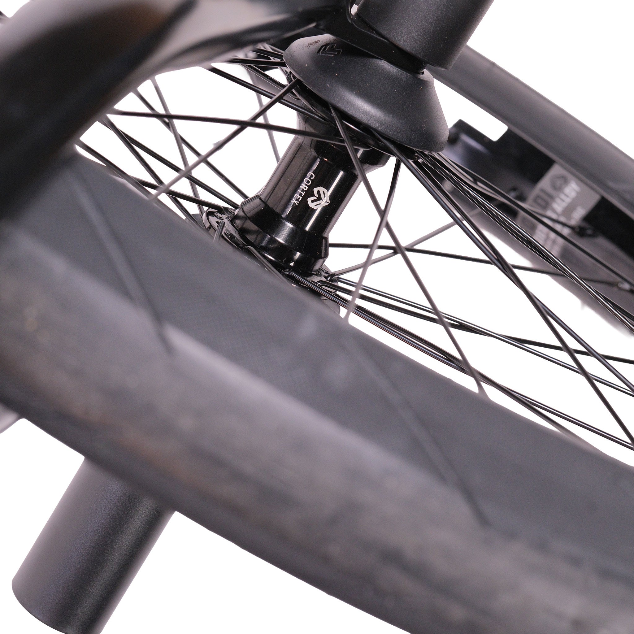 Close-up of a BMX bike wheel with hub, spokes, and tire visible; a small section of the Cult Dak X Eclat Custom 'Pat Freyne Signature' frame appears in the background.