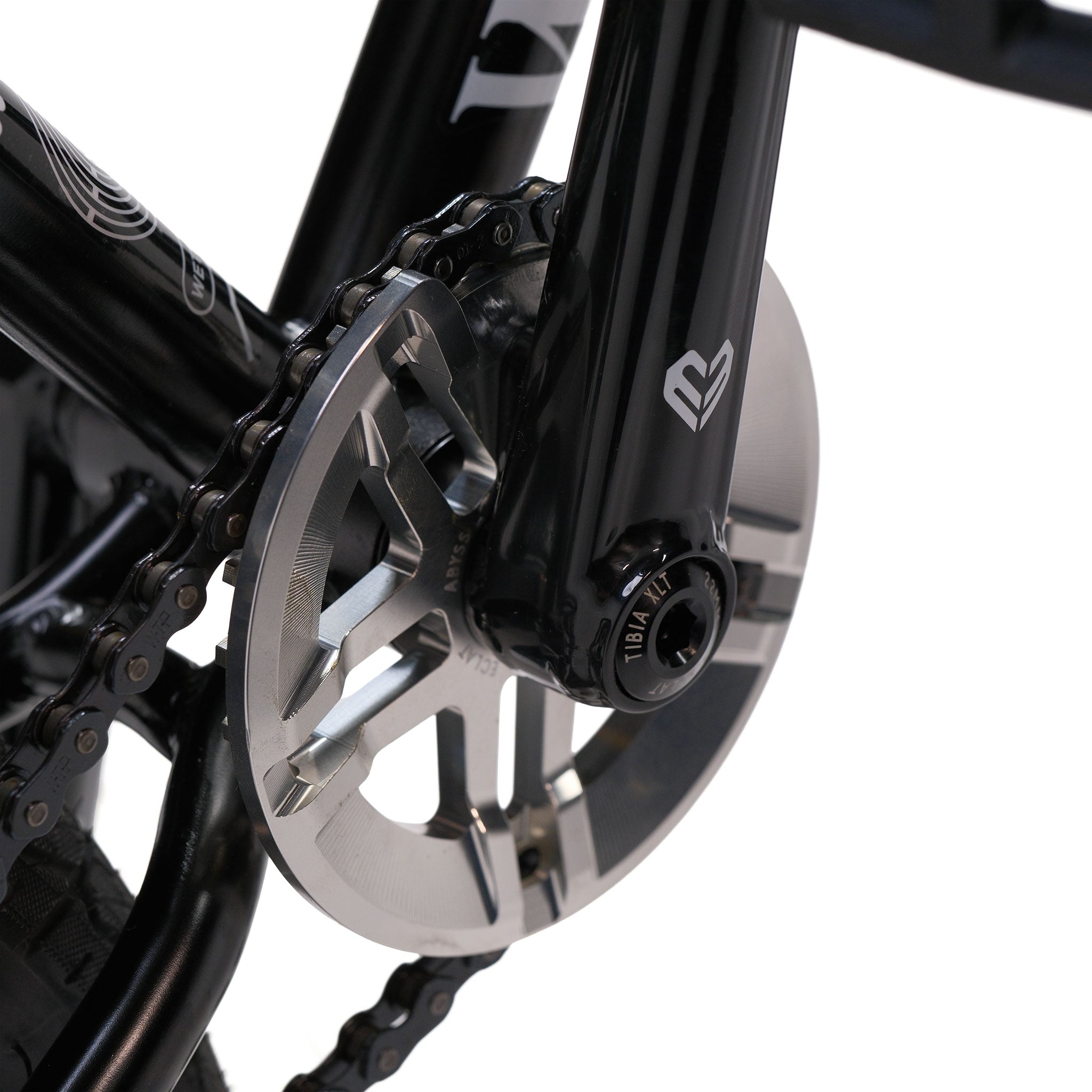 Close-up of a Wethepeople Prodi-G-Unit 18 Inch Custom Bike crankset showing the pedal arm, chainring, chain, and crank bolt—featuring Eclat parts—on a black bike frame, photographed against a white background.