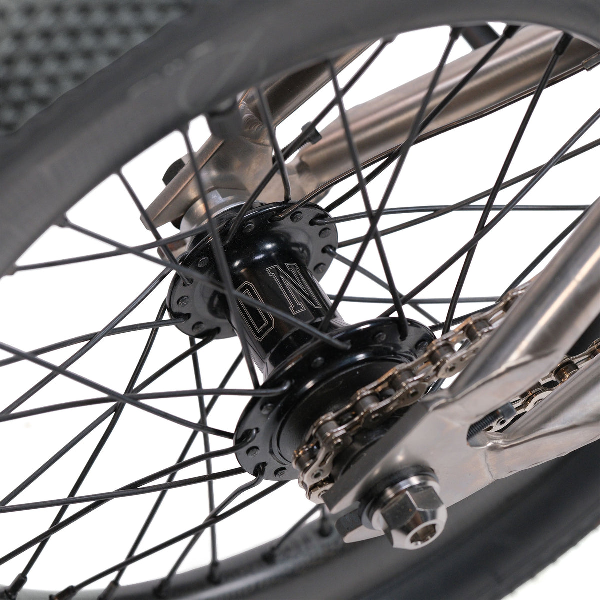 Close-up of a bicycle rear wheel showing the metal hub, spokes, axle, and chain against a neutral background—perfect for highlighting the precision engineering of the ION BMX Ti16 Custom Titanium 16 Inch Bike.