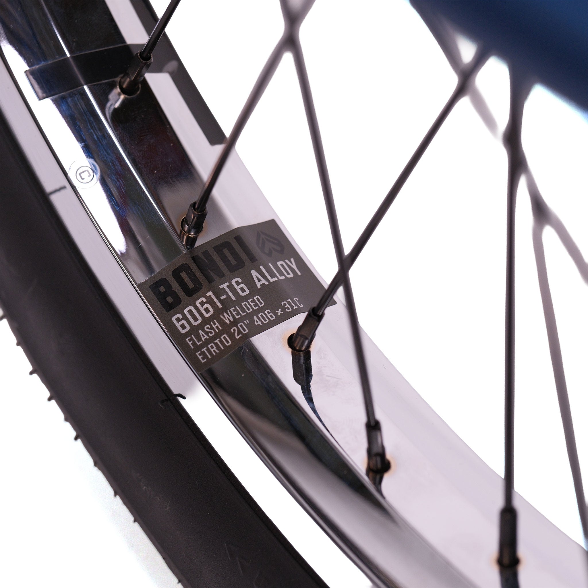Close-up of the Wethepeople Tomorrow X TA Custom build BMX wheel, showcasing metal spokes, tire, and a rim label reading "BONDI 6061-T6 ALLOY FLASH WELDED ETRTO 20 406-39L.