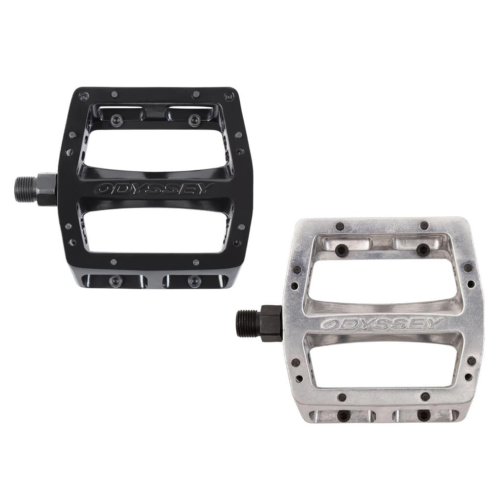 Two Odyssey Trail Mix Loose Ball Pedals, one black and one silver with rectangular shapes and "ODYSSEY" branding, are shown side by side on a white background.