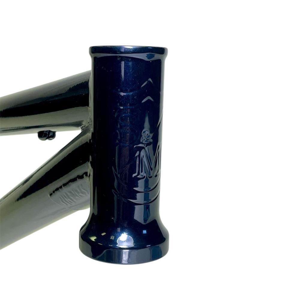Close-up of the S&M Big Jumper V2 26 Inch dirt jumper frame's dark blue head tube with embossed logo, isolated on a white background.