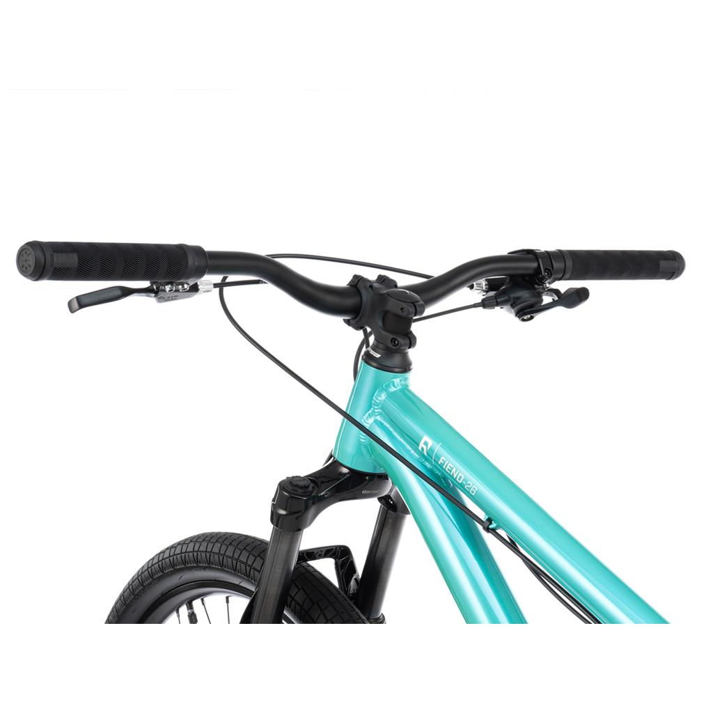 Close-up of the handlebars, brake levers, and front section of the Radio Fiend 26 Inch Bike in turquoise alloy set against a white background.