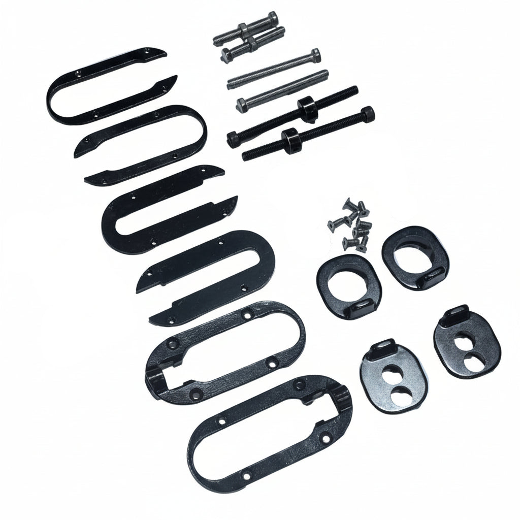 Assorted black metal brackets, plates, screws, and bolts arranged on a white background, including chain tensioner plates and dropout plates from the Chase ACT 1.2 Complete Drop Out Kit, showcasing a variety of hardware components.