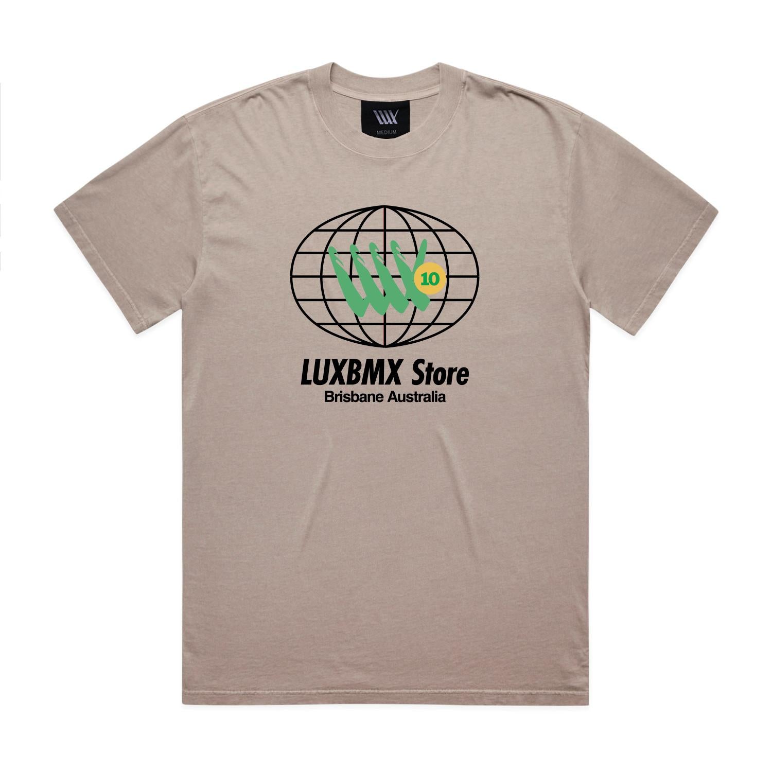 LUXBMX Eighty Eight Tee Faded Mushroom: A beige t-shirt featuring a black globe graphic, green hand symbol, "LUXBMX Store" text, and "Brisbane Australia" printed below the design—a subtle nod to Brisbane’s vibrant spirit and its iconic World Expo 88 heritage.