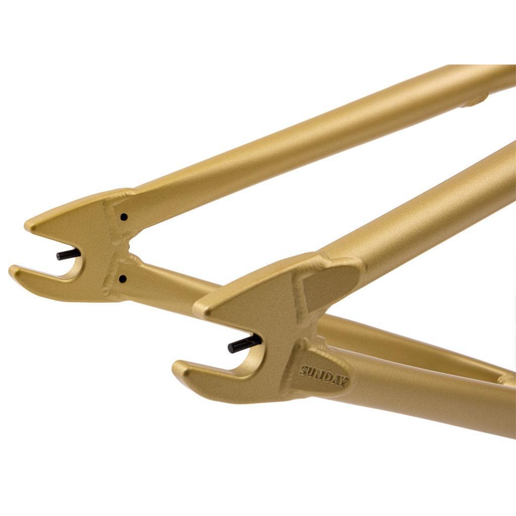 Close-up of the rear dropouts on a metallic gold Sunday Wavelength Frame, highlighting the axle slots and "SUNDAY" branding embossed on durable 4130 chromoly.