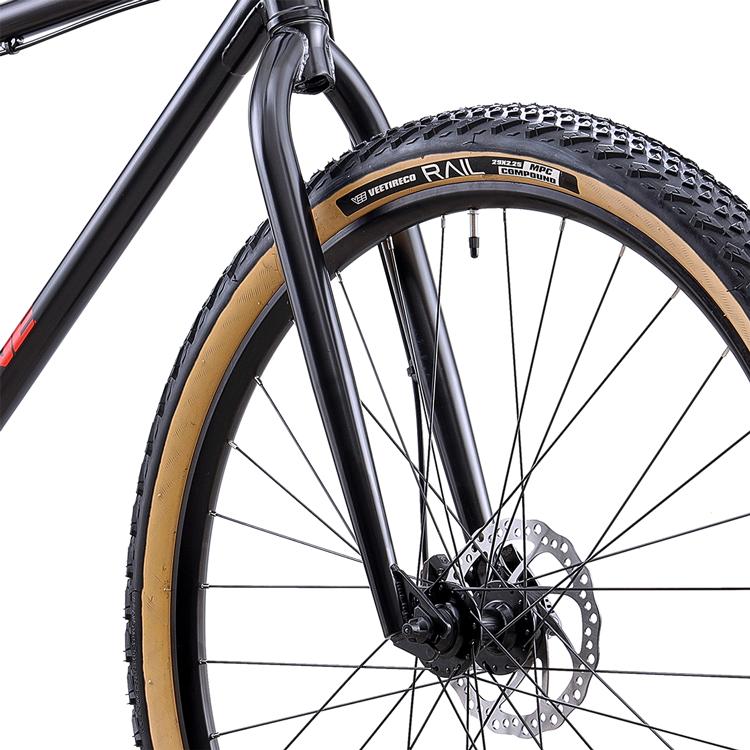 Close-up of a Redline Monocog 29 Inch Bike’s front wheel with a knobby tire, tan sidewall, disc brake rotor, and black fork.