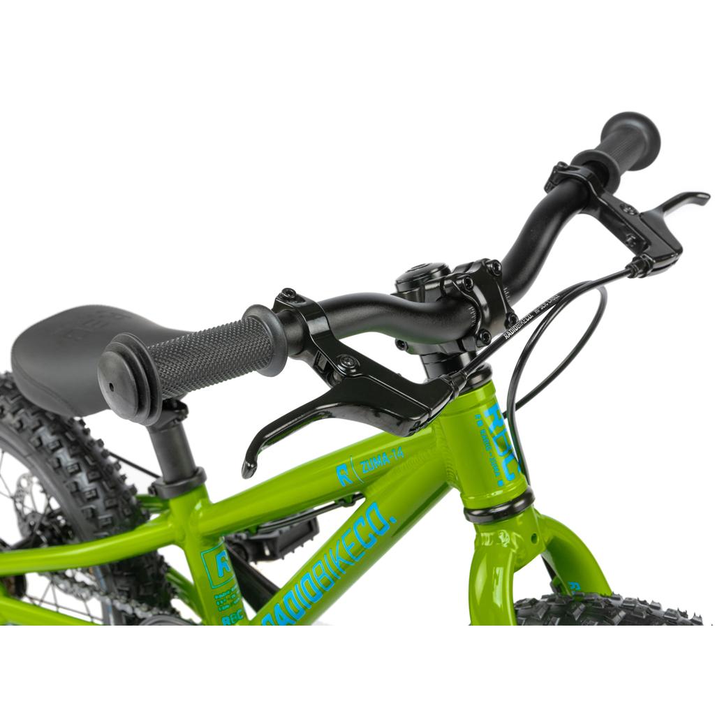 Close-up of the handlebars and front frame of the Radio Zuma 14 Inch Bike, a lightweight kids mountain bike, highlighting hand grips, brake levers, part of the seat, and tires.