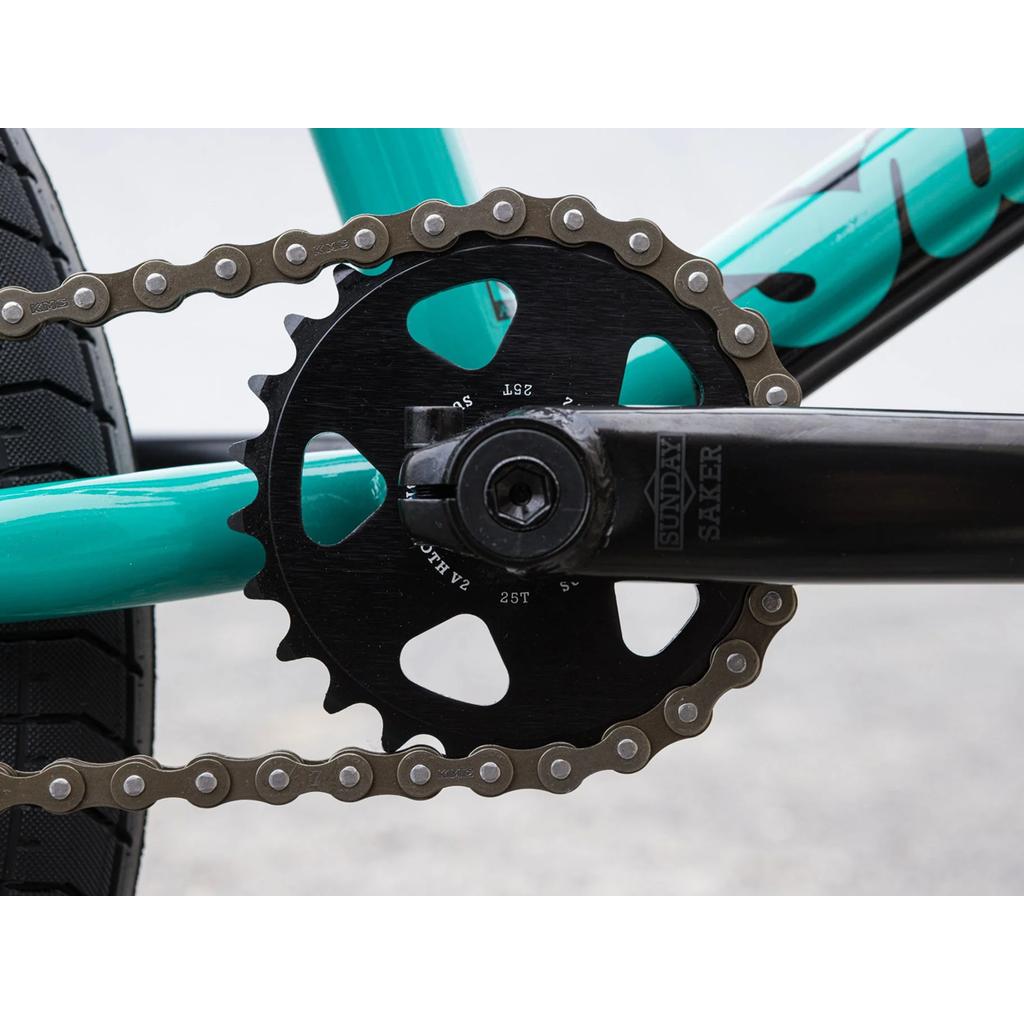 Close-up of the Sunday EX Erik Elstran 20 Inch Bike crankset, showing the chainring, crank arm, and chain with Odyssey components against a blurred background.