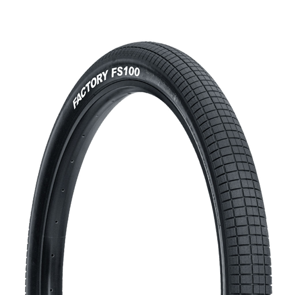 A Tioga FS100 26 Inch tire with the label "factory fs100" displayed on the sidewall.