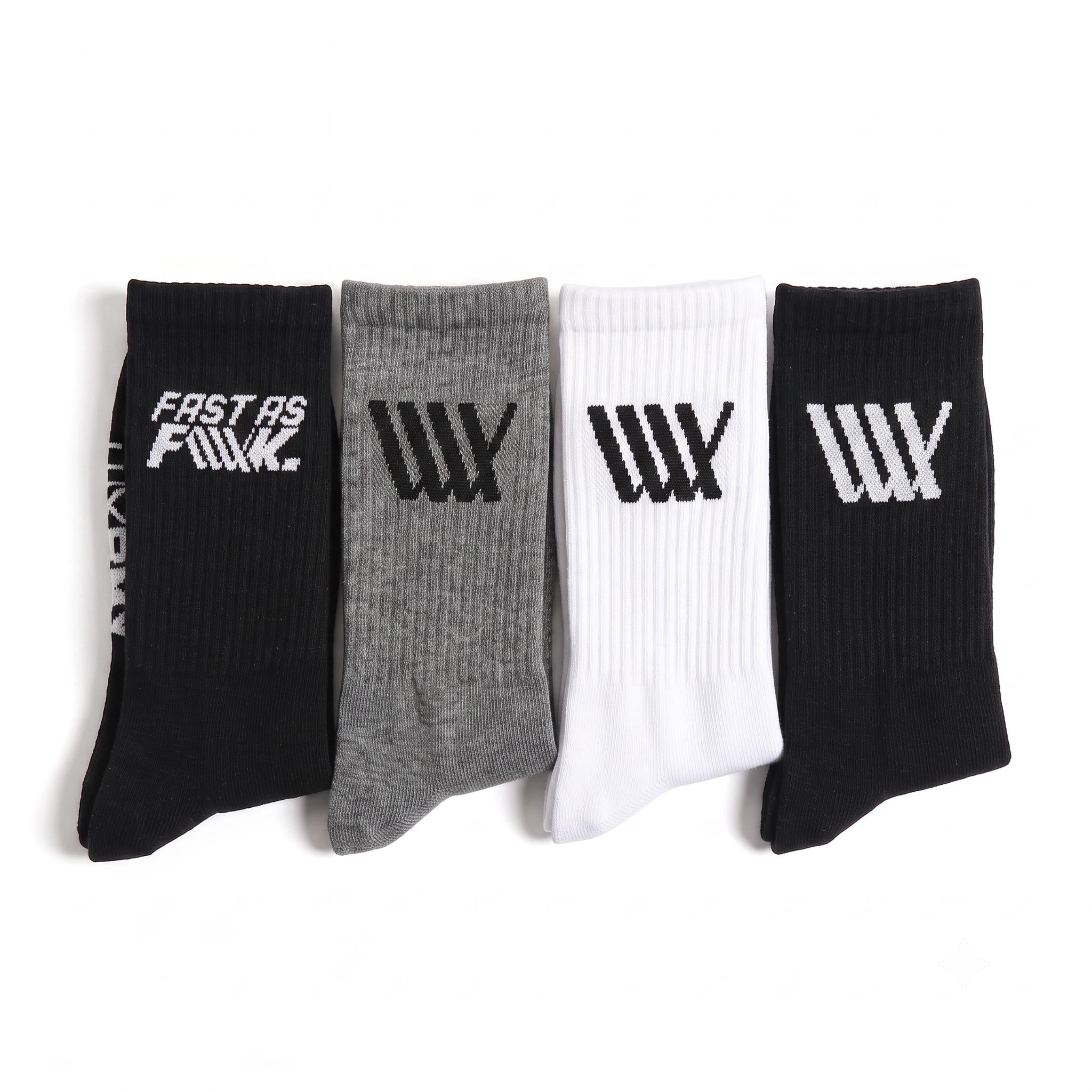 Four pairs of LUXBMX Crew Socks (4 Pack Mix)—in black, gray, white, and black—are displayed side by side, each showcasing striking graphic logos or text on the cuffs. Crafted for both comfort and durability, these crew socks are perfect for BMX riders who want a blend of style and performance.