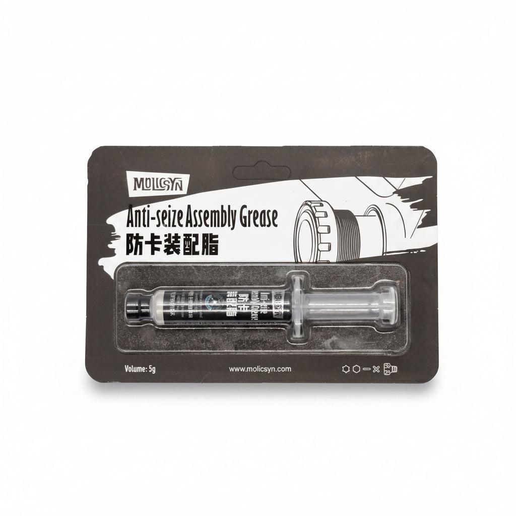 A 5g syringe of MolicSYN Prime Anti-Seize Grease, a high-performance bike anti-seize lubricant, in black packaging with English and Chinese text and a background graphic of gears.