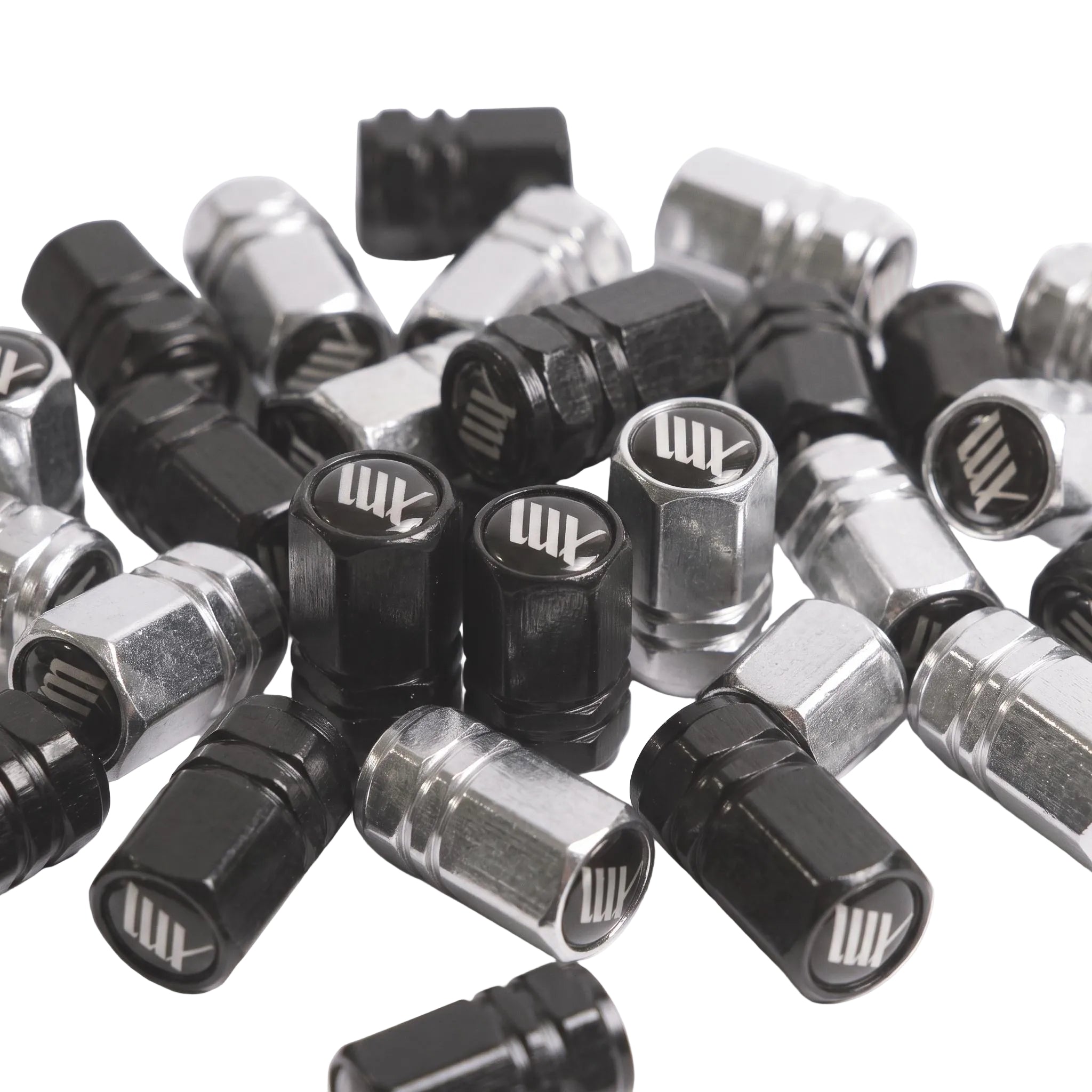 A pair of LUXBMX Hex Logo Alloy Valve Caps, featuring a black and silver machined finish and white "AM" logo—premium accessories perfect for adding custom style to your BMX ride.
