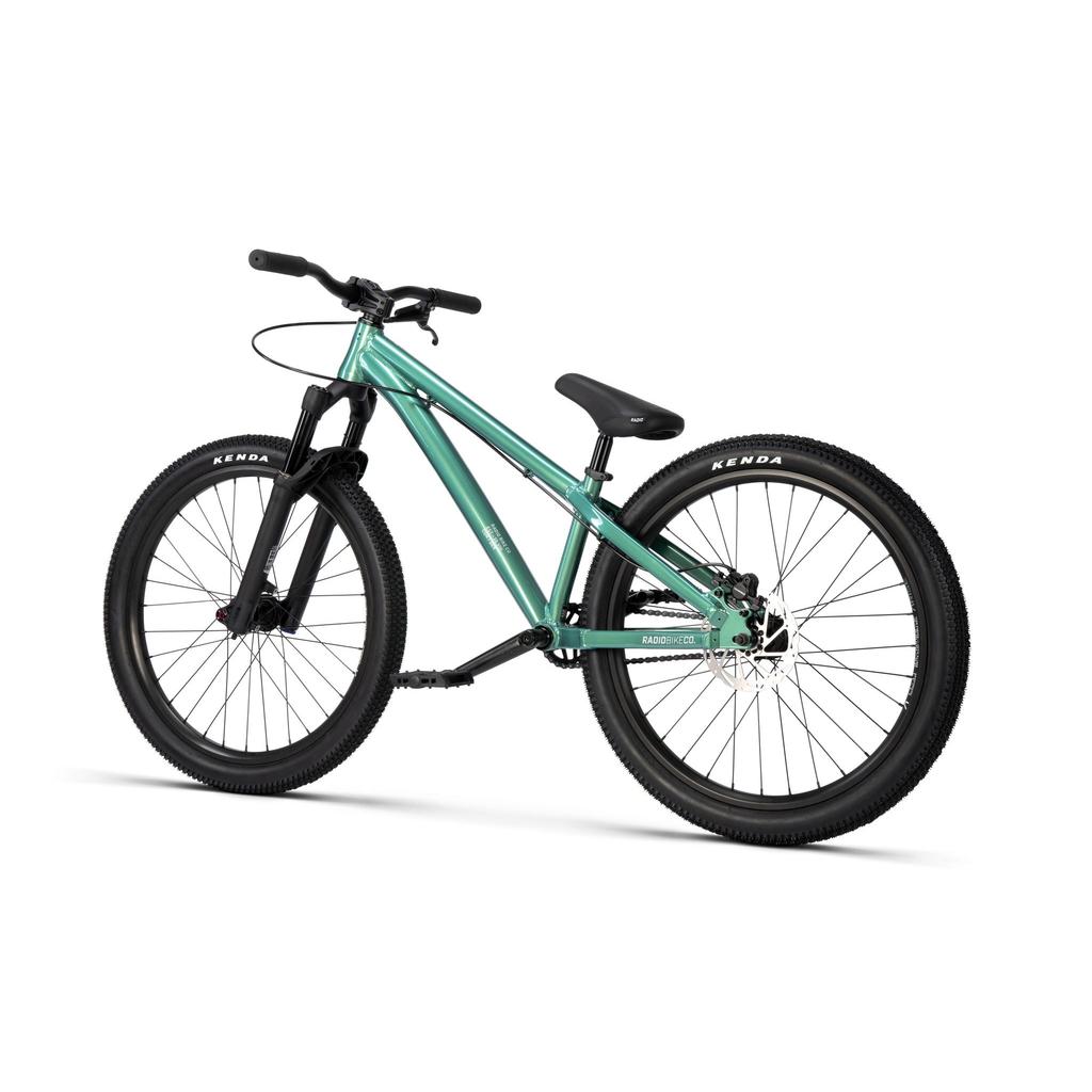 The Radio Griffin 24 Inch Dirt Jumper Bike, featuring a green frame, thick black tires, disc brakes, and a black saddle, is positioned at an angle on a white background.