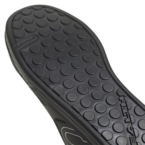 Close-up of the black rubber sole on Five Ten Freerider Pro Flat Core Shoes BLK/FTWR WHT, showing a circular dot traction pattern for grip and embossed branding.
