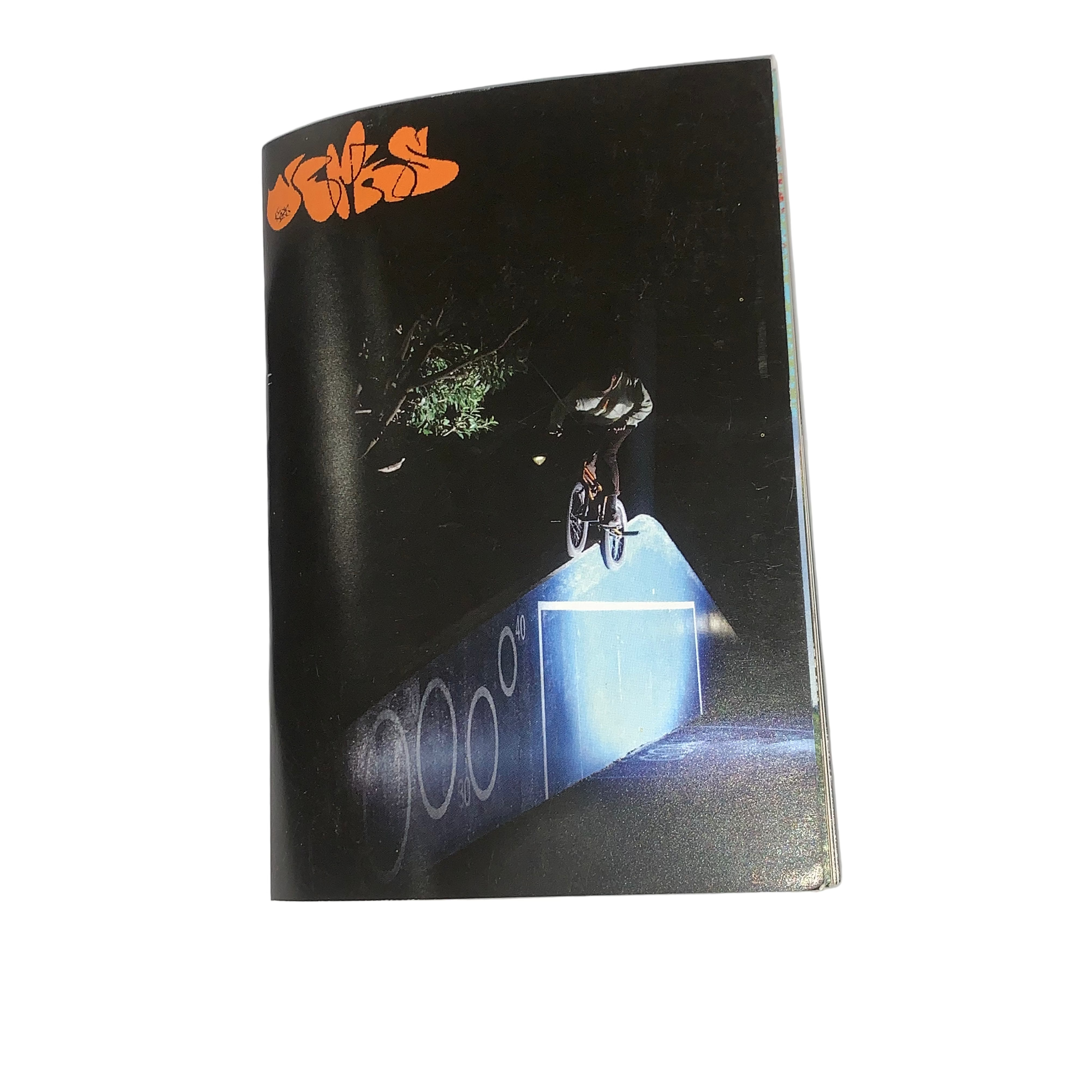 A BMX rider performs a ramp trick at night in Kirkham Skate Park, lit by a blue spotlight, with "Jerk Zine Volume 1" in bold orange graffiti-style text at the top.