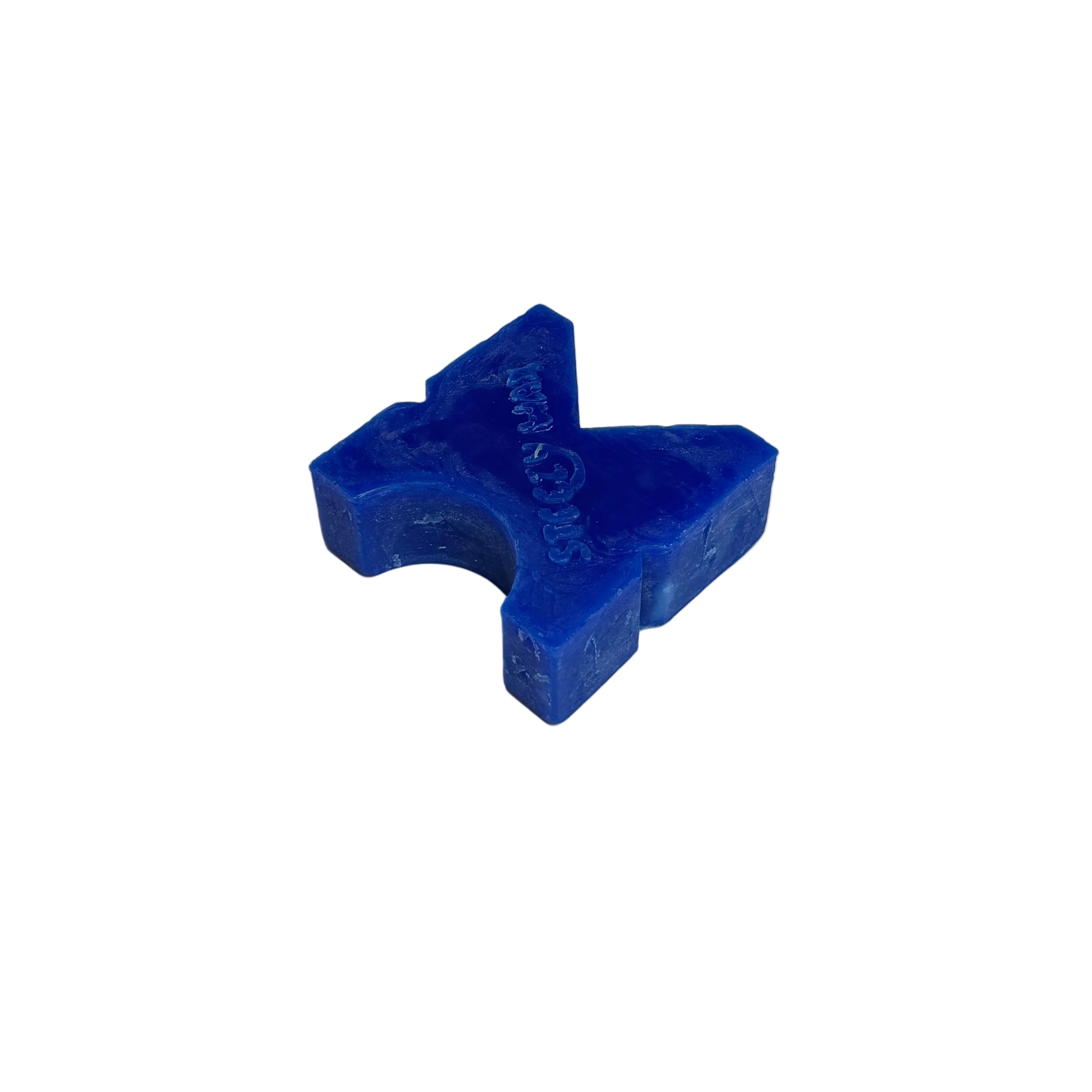 A blue, arrow-shaped Steezy Wax / K-Slide skate wax rests on a white surface against a neutral background. This wax block is handmade in Australia.