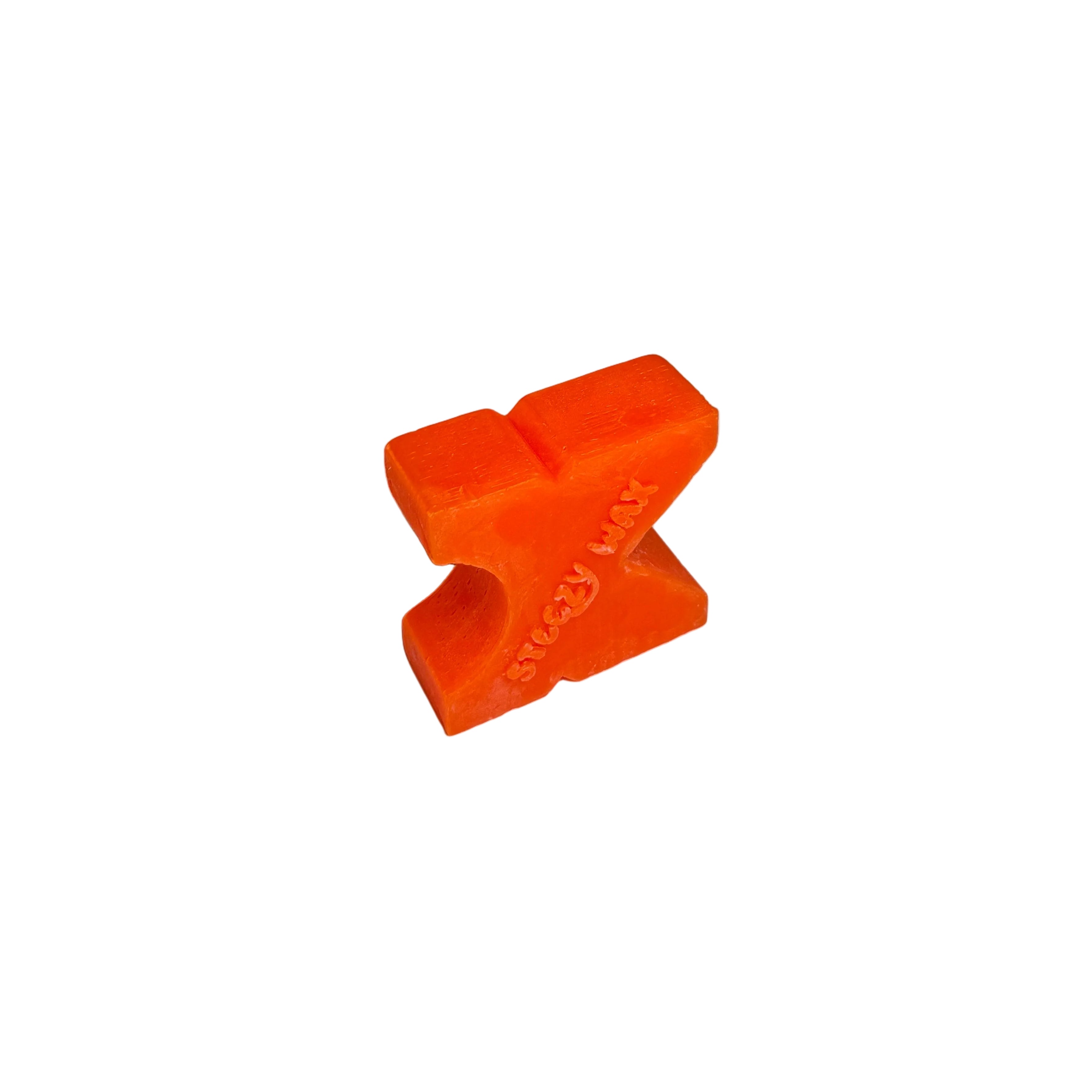 A handmade, orange, X-shaped Steezy Wax K-Slide skate wax block with embossed text sits on a white surface against a gray background.