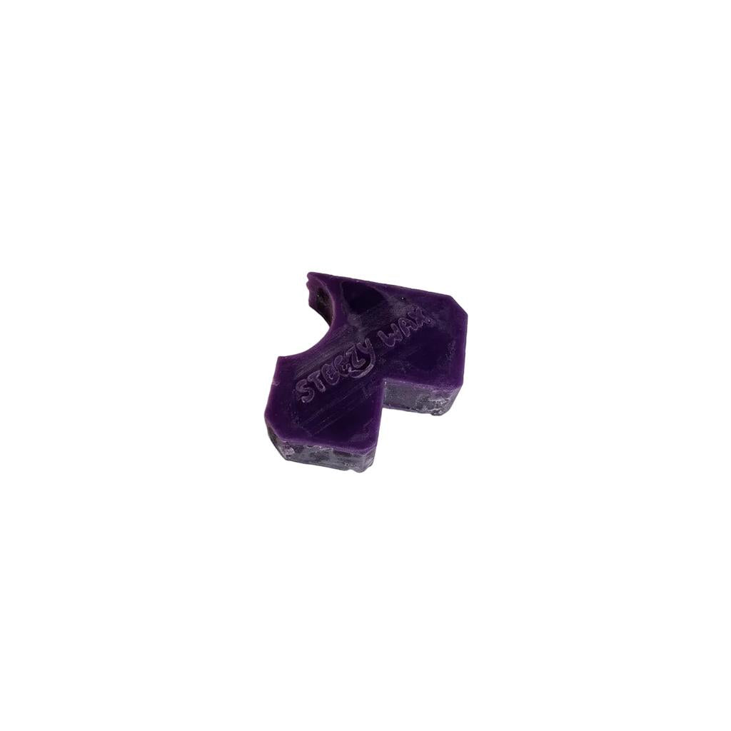 The Steezy Wax / Straya is a handmade purple arrow-shaped skate wax with "STEEZY WAX" embossed on it, crafted in Australia, and features a small chunk missing.