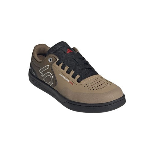 The Five Ten Freerider Pro Flat Core Shoes in CRDBRD/OFF WHT/CORE offer pedal-gripping control with a brown and black design, black laces, perforated toe area, and a white side logo, shown against a plain white background.