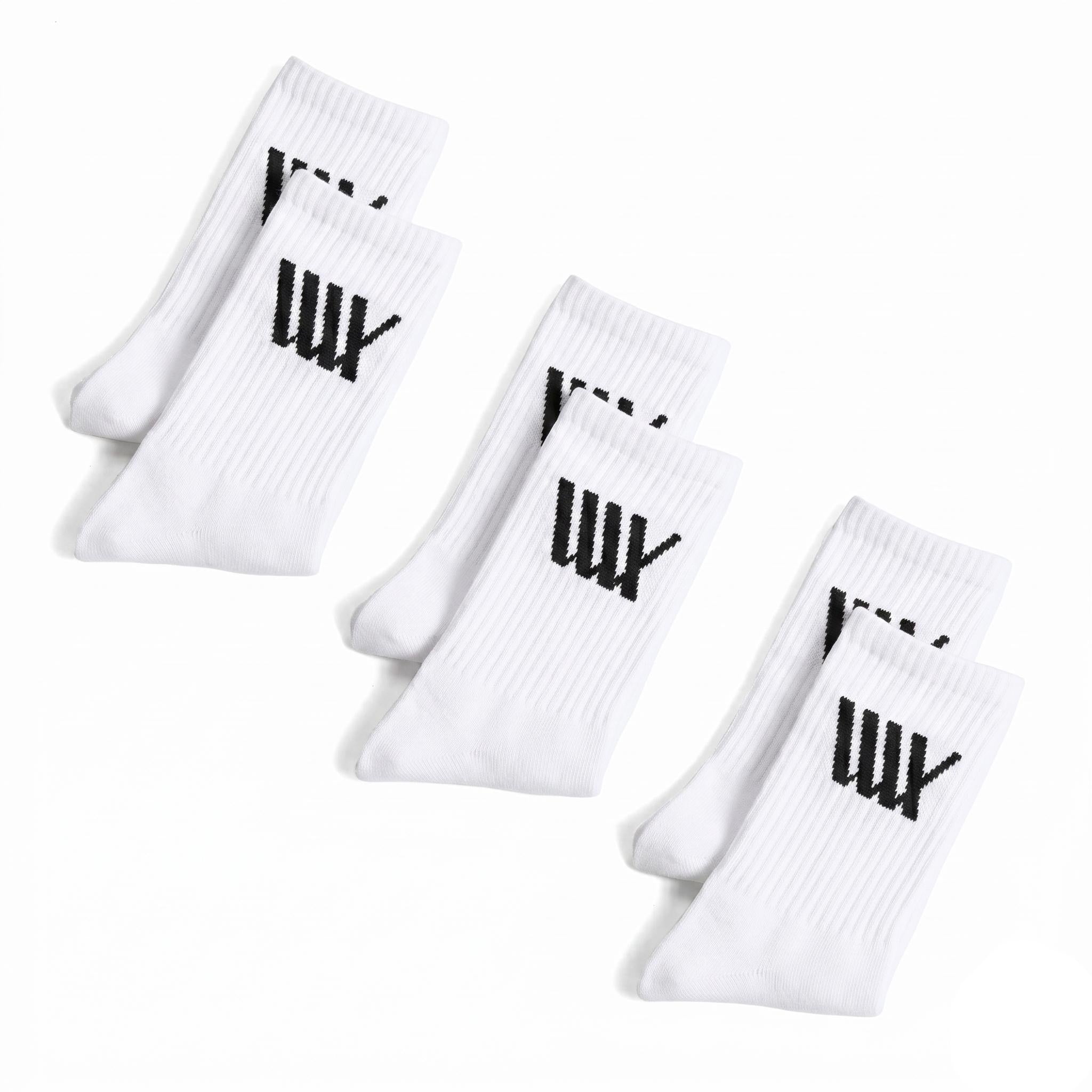 Three pairs of LUXBMX Crew Socks (3 pack) in white, arranged in two rows. Each sock features a bold black logo on the cuff—ideal for BMX riding.