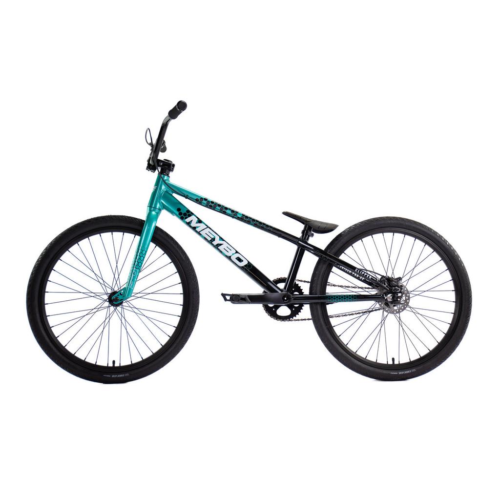 The Meybo 2026 Clipper Pro Cruiser Bike features a teal and black frame, single gear, flat handlebars, and thick tires—seen from the side against a white background—making it an ideal entry-level race bike for new riders.