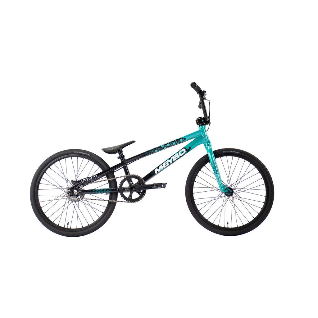 Side view of the Meybo 2026 Clipper Expert XL Bike in teal and black with 20-inch tires, single gear, flat seat, and straight handlebars against a white background—an ideal entry-level BMX race bike.